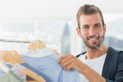 Handsome male customer by clothes rack