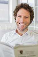 Portrait of a smiling man reading newspaper