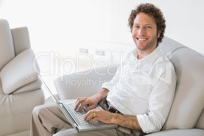 Well dressed man using laptop at home