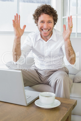 Worried well dressed man with laptop at home