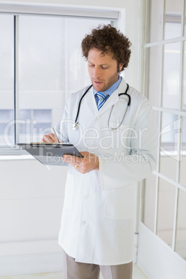 Male doctor writing reports in hospital