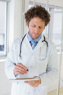 Serious male doctor writing reports