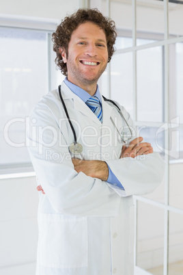 Male doctor standing with arms crossed in the hospital