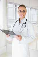 Beautiful female doctor with clipboard in hospital