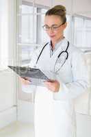 Beautiful female doctor with clipboard in hospital