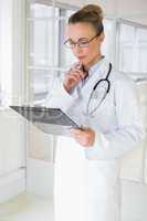 Beautiful female doctor with clipboard in hospital