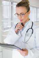 Beautiful female doctor with clipboard in hospital