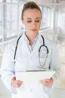 Beautiful female doctor with clipboard in hospital