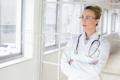 Serious female doctor with arms crossed in hospital