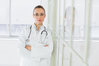 Serious female doctor with arms crossed in hospital