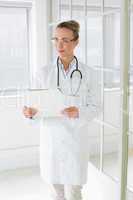 Beautiful female doctor with clipboard in hospital