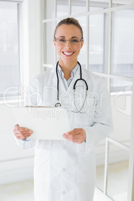 Beautiful female doctor with clipboard in hospital