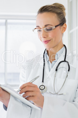 Beautiful female doctor with clipboard in hospital