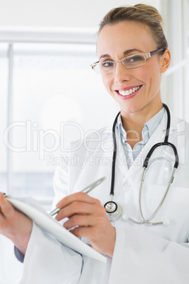 Beautiful female doctor with clipboard in hospital