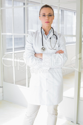 Serious female doctor with arms crossed in hospital Serious female doctor with arms crossed in hospital