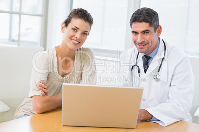 Doctor and patient using laptop in medical office