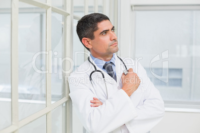 Thoughtful male doctor looking away in hospital