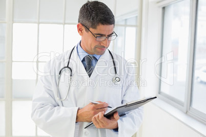 Serious male doctor writing reports