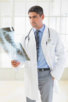 Serious male doctor examining xray