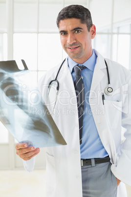 Portrait of a smiling male doctor holding xray