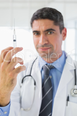 Portrait of male doctor holding an injection