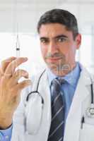 Portrait of male doctor holding an injection