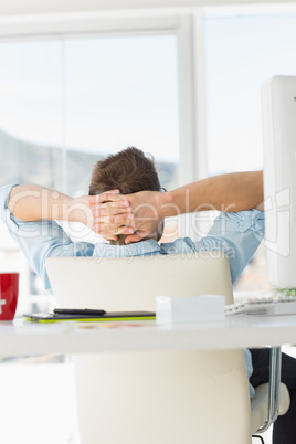 Young designer relaxing at his desk