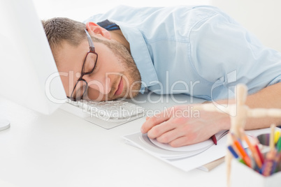 Young designer sleeping at his desk