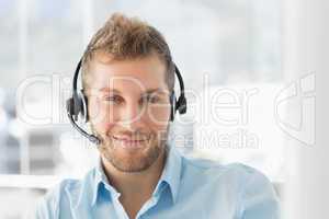 Handsome call centre agent wearing a headset