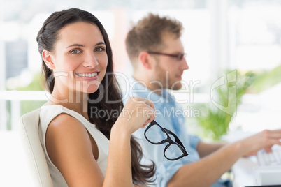 Beautiful designer smiling at camera at desk