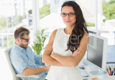 Pretty designer looking at camera leaning on desk