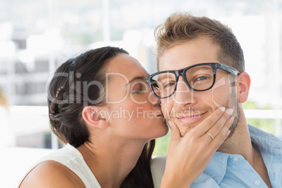 Attractive young designer getting a kiss from a co worker