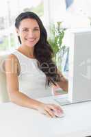 Cheerful businesswoman sitting at her desk