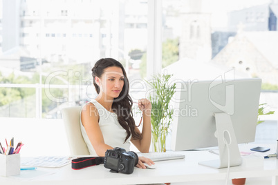 Beautiful focused photographer working at her desk