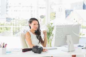 Beautiful focused photographer working at her desk