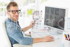 Handsome editor working at his computer smiling at camera