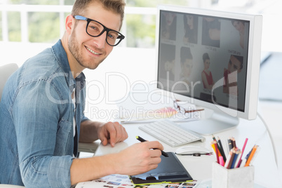 Handsome editor working with digitizer smiling at camera