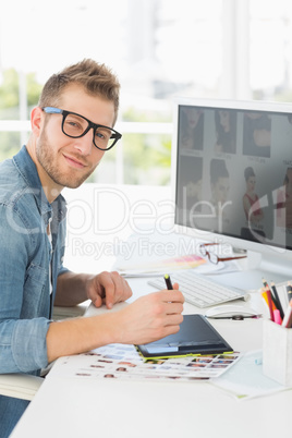 Handsome editor working with digitizer looking at camera