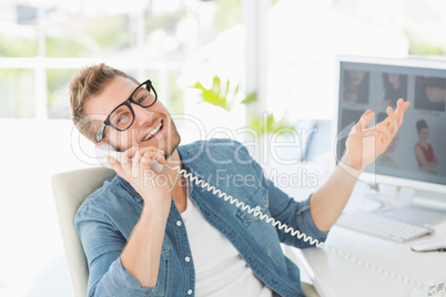 Handsome designer laughing on the telephone looking at camera