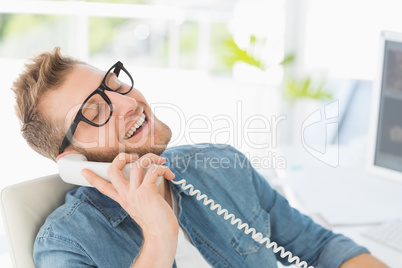 Handsome designer laughing on the telephone