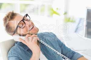 Handsome designer laughing on the telephone