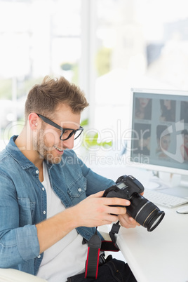 Handsome photographer holding his camera and smiling