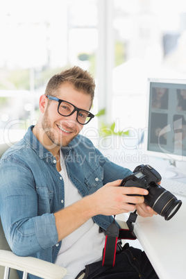 Photographer holding his camera and smiling at camera