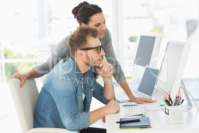 Team of designers looking at the computer