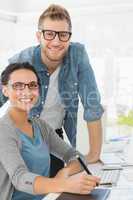 Young attractive design team at desk smiling at camera
