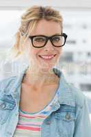 Pretty blonde designer wearing glasses smiling at camera