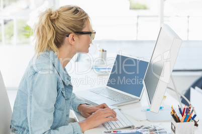 Blonde designer working at her desk