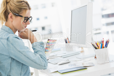 Blonde focused designer working at her desk