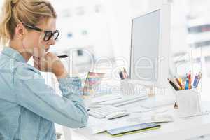 Blonde focused designer working at her desk