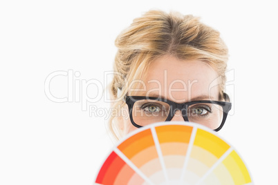 Blonde designer wearing glasses holding colour wheel
